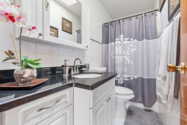 bathroom with tile flooring, tasteful backsplash, toilet, and vanity