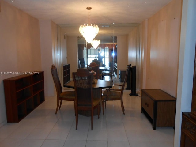 dining space featuring light tile patterned flooring and an inviting chandelier