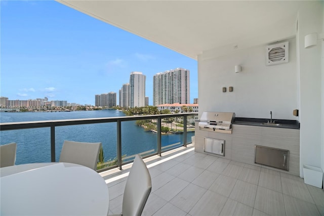 balcony with sink, a water view, and a grill