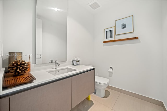 bathroom featuring tile patterned floors, vanity, and toilet