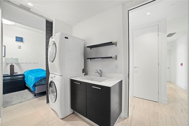 laundry area with sink and stacked washer / dryer