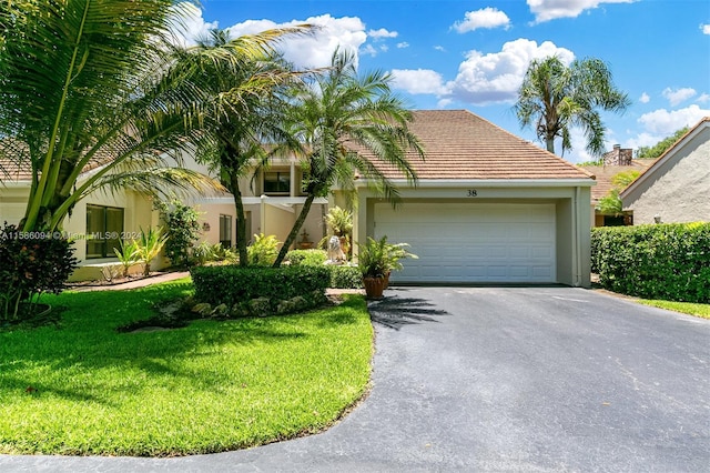 view of front of home with a garage and a front lawn