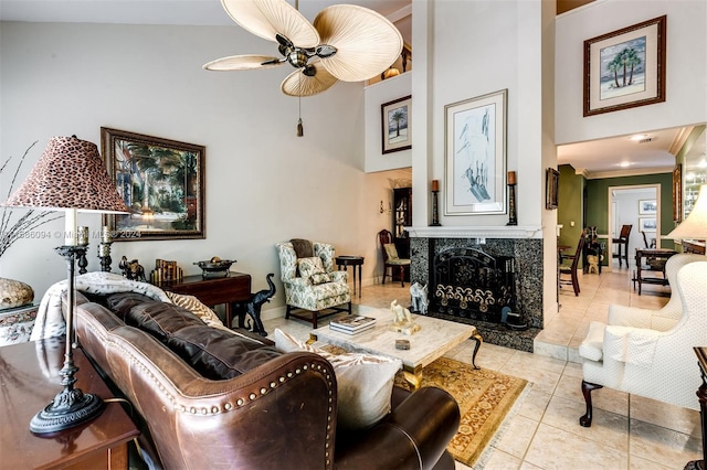 living room with high vaulted ceiling, light tile patterned floors, a high end fireplace, ceiling fan, and ornamental molding