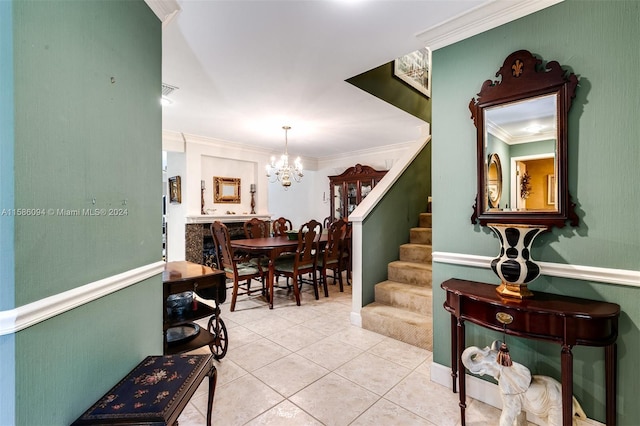 foyer entrance with a notable chandelier, tile patterned floors, and crown molding