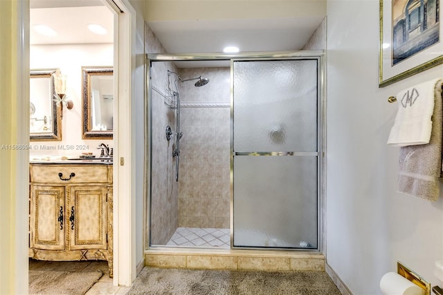 bathroom featuring a shower with door and vanity