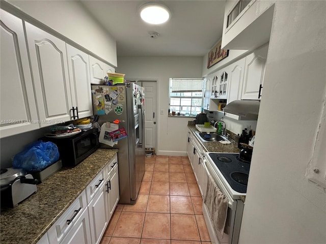 kitchen featuring white cabinets, stainless steel refrigerator with ice dispenser, light tile flooring, range with two ovens, and sink