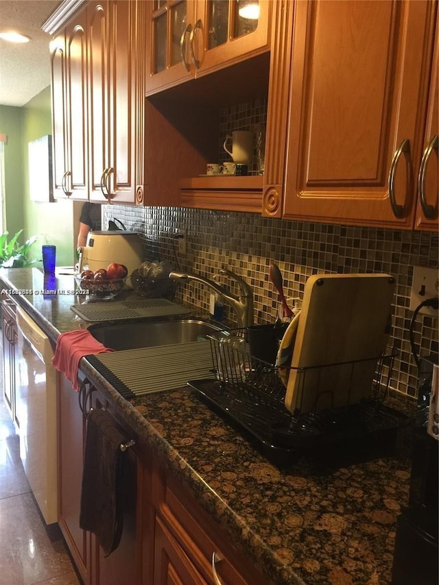 kitchen with backsplash, dishwasher, a textured ceiling, and dark stone counters