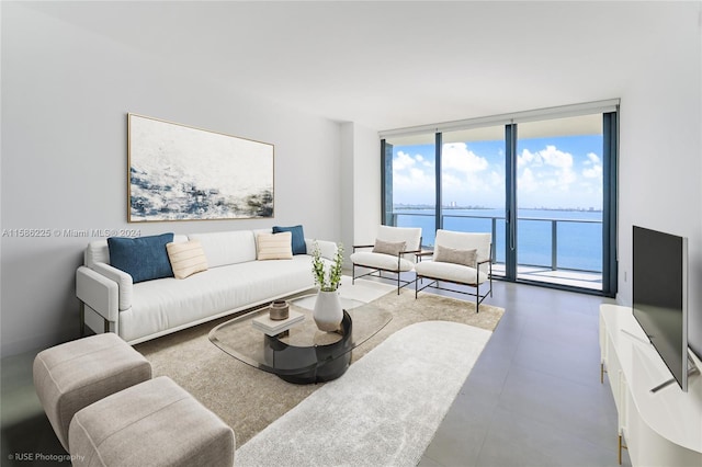 tiled living room with a wall of windows and a water view