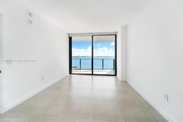 tiled empty room featuring floor to ceiling windows