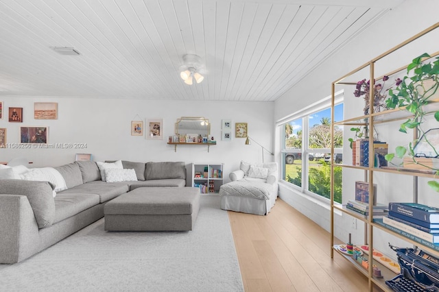 living room featuring ceiling fan, light wood-type flooring, and wooden ceiling