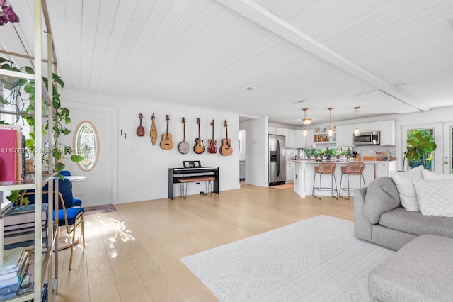 living room with beam ceiling and light hardwood / wood-style floors