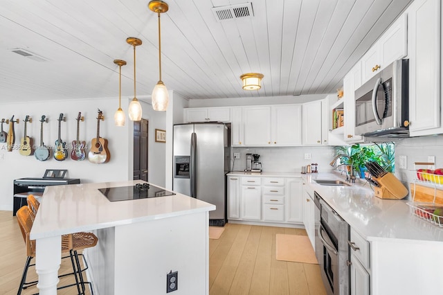 kitchen featuring light hardwood / wood-style floors, stainless steel appliances, backsplash, white cabinets, and wooden ceiling