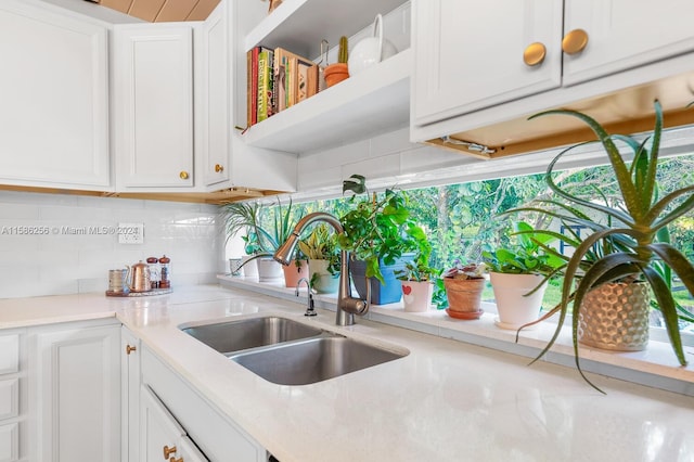 kitchen with sink, white cabinets, and tasteful backsplash