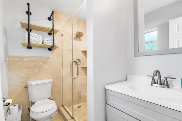 bathroom with an enclosed shower, large vanity, and toilet