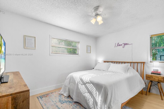 bedroom featuring a textured ceiling, ceiling fan, and hardwood / wood-style floors