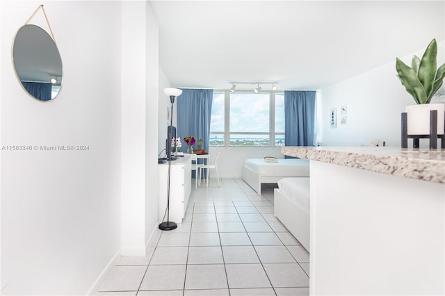 bathroom with tile floors, rail lighting, and a bathing tub