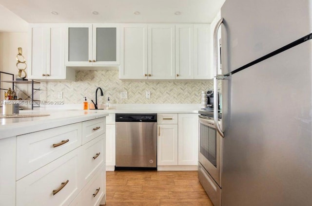 kitchen featuring backsplash, stainless steel appliances, and white cabinetry