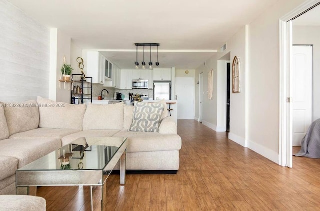 living room with light wood-type flooring and sink