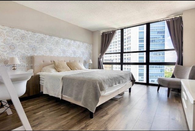 bedroom featuring a textured ceiling, dark hardwood / wood-style floors, and expansive windows