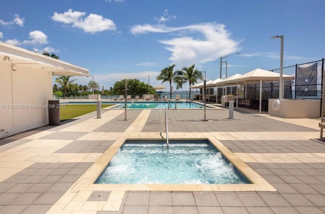 view of swimming pool featuring a patio and a hot tub