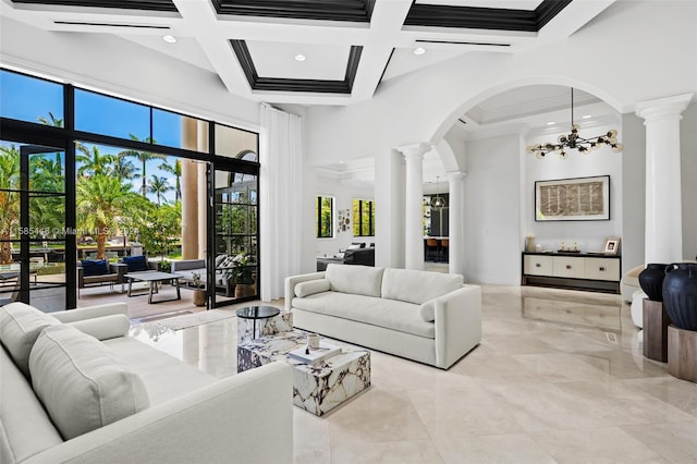 tiled living room featuring a towering ceiling, coffered ceiling, and decorative columns