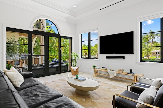 living room featuring tile flooring, a healthy amount of sunlight, crown molding, and french doors