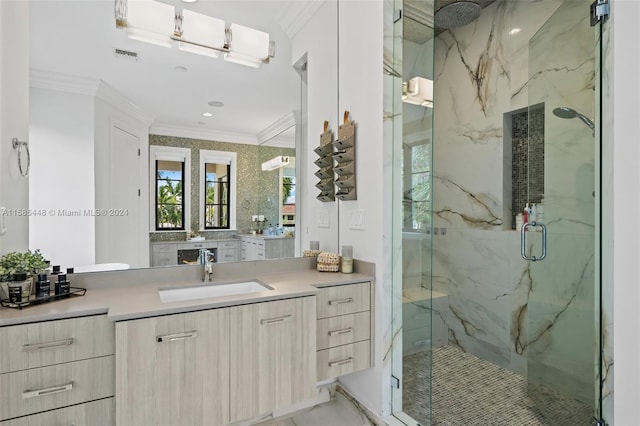 bathroom with a shower with shower door, vanity, and crown molding