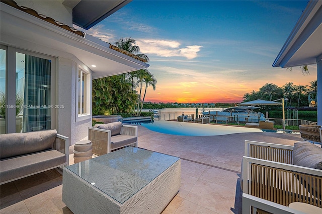 pool at dusk featuring outdoor lounge area, a jacuzzi, a water view, and a patio