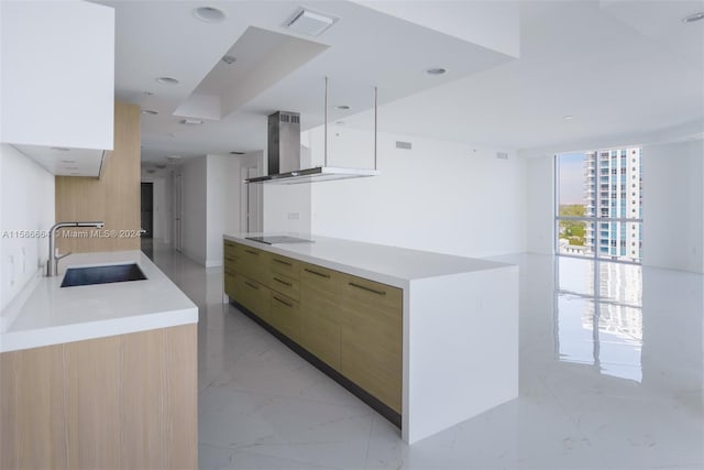 kitchen with wall chimney range hood, white cabinetry, expansive windows, sink, and light tile floors