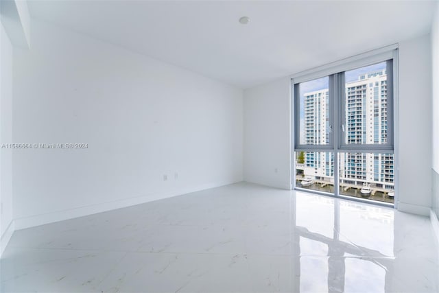 unfurnished room featuring tile floors and floor to ceiling windows