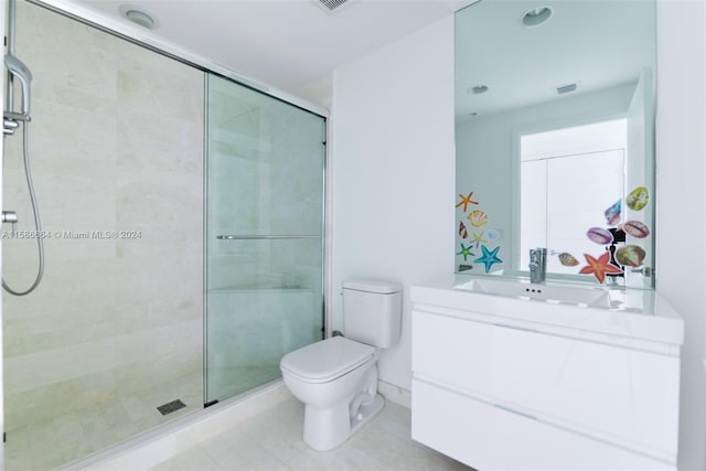 bathroom with tile flooring, an enclosed shower, vanity, and toilet