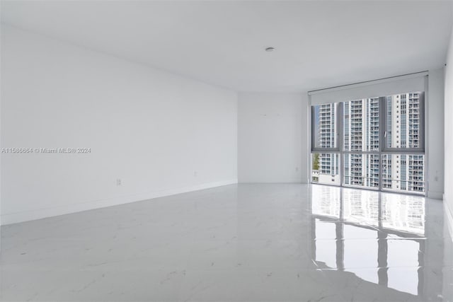 tiled spare room with a wall of windows