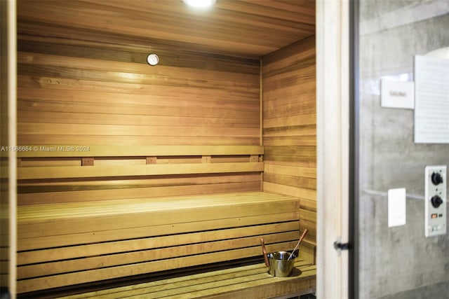 view of sauna / steam room featuring wooden ceiling and wood walls