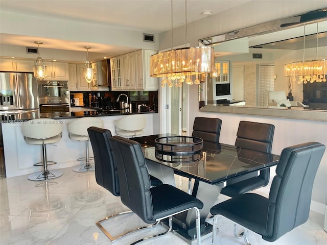 dining area featuring a chandelier, sink, and light tile floors