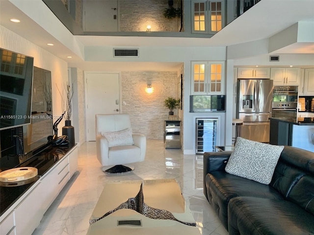 living room with a towering ceiling and light tile floors