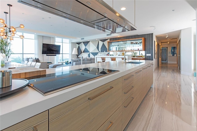 kitchen with decorative light fixtures, a chandelier, light hardwood / wood-style flooring, backsplash, and sink