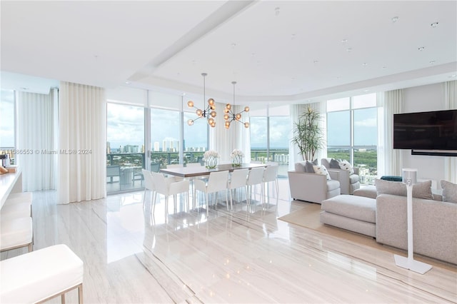 tiled living room with plenty of natural light, expansive windows, and an inviting chandelier