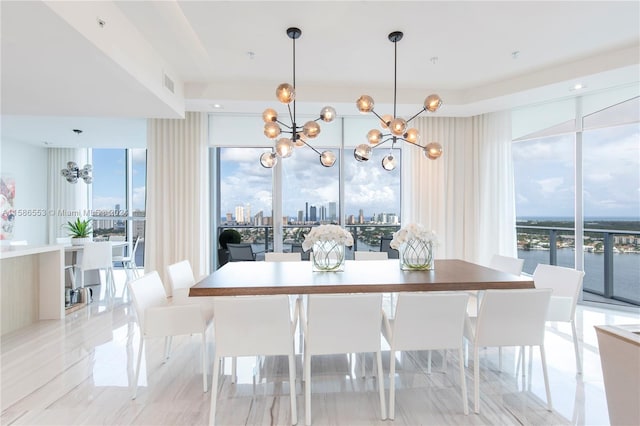 tiled dining room featuring plenty of natural light and a chandelier