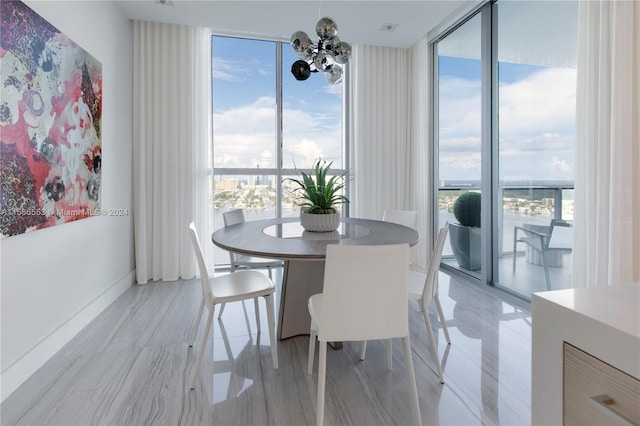 dining area with a wealth of natural light, a notable chandelier, and a wall of windows