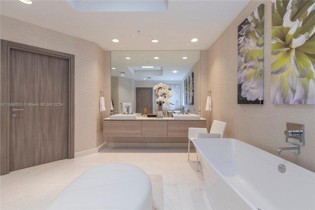 bathroom with a tub, double sink vanity, and tile floors