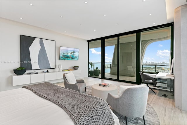 bedroom featuring floor to ceiling windows, light wood-type flooring, and access to outside