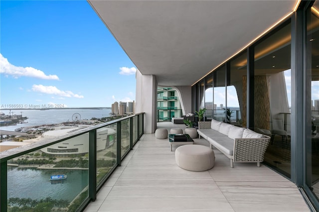 balcony featuring an outdoor living space and a water view