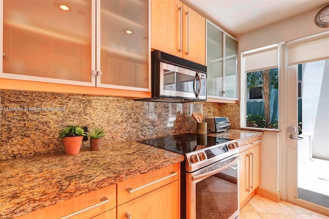 kitchen with stainless steel appliances, tasteful backsplash, stone countertops, and light tile floors