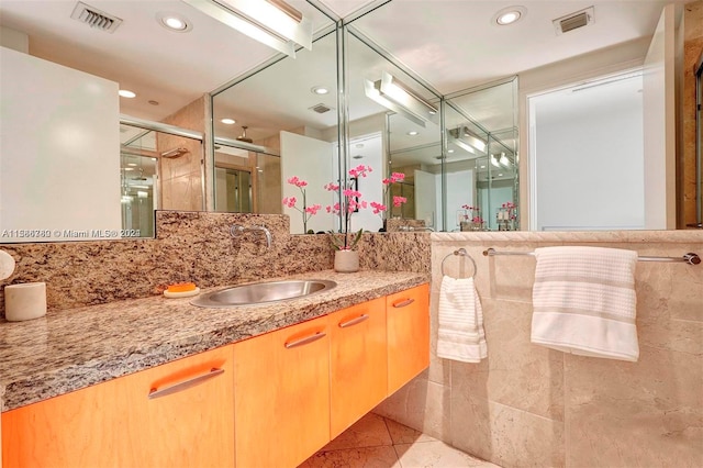 bathroom with oversized vanity, tile walls, and tile floors