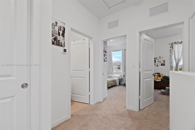 hall featuring light colored carpet