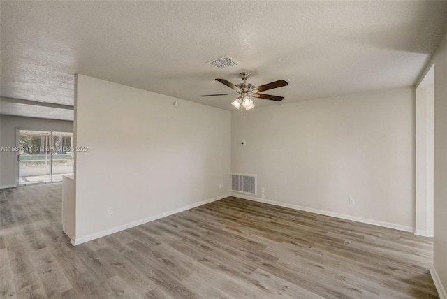 spare room featuring a textured ceiling, wood-type flooring, and ceiling fan