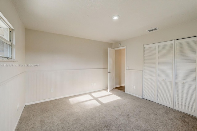 unfurnished bedroom featuring carpet and a closet