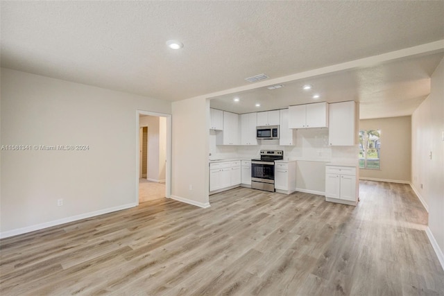 unfurnished living room featuring a textured ceiling and light wood-type flooring