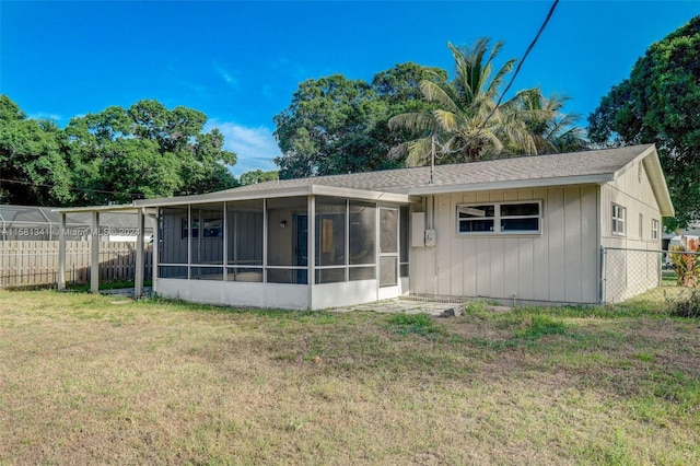 back of house featuring a sunroom and a yard