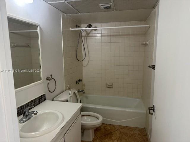 full bathroom featuring tile patterned floors, vanity, toilet, and tiled shower / bath